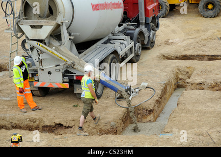 Baustelle zeigt Streifen Stiftung Gräben und Betonmischer liefern konkrete. Stockfoto