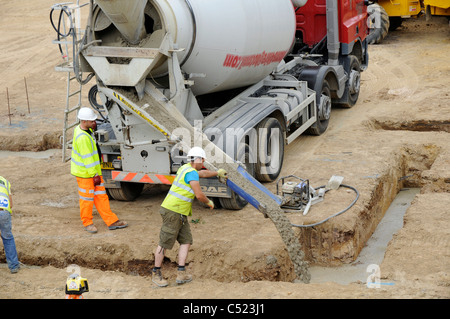 Baustelle zeigt Streifen Stiftung Gräben und Betonmischer liefern konkrete. Stockfoto