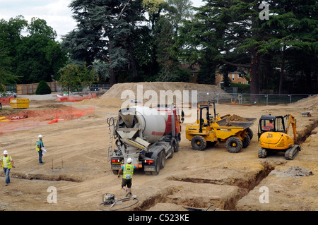 Baustelle zeigt Streifen Stiftung Gräben und Betonmischer liefern konkrete. Stockfoto