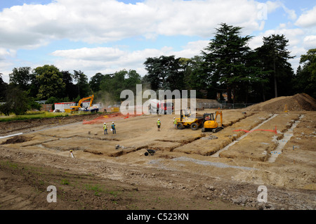 Baustelle zeigt Streifen Stiftung Gräben und Betonmischer liefern konkrete. Stockfoto