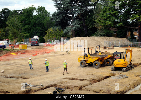 Baustelle zeigt Streifen Stiftung Gräben und Betonmischer liefern konkrete. Stockfoto