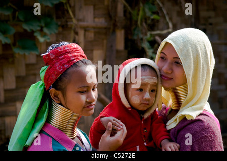 Eine Karen Paduang Flüchtling Trägerin gold Ringe um den Hals trägt ein junges Baby in einem Flüchtlingslager in Nord-Thailand Stockfoto