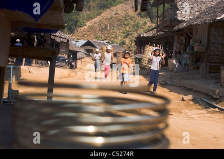 Ethnische Hill Tribe Frauen tragen Körbe mit trockenen Blättern in einem Flüchtlingslager im Norden Thailands. Stockfoto