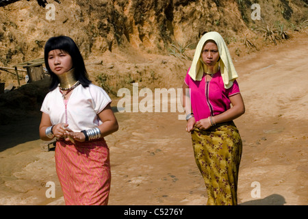 Karen Paduang Flüchtlingsfrauen tragen goldene Ringe um den Hals gehen auf einer Straße in einem Flüchtlingslager in Nord-Thailand. Stockfoto