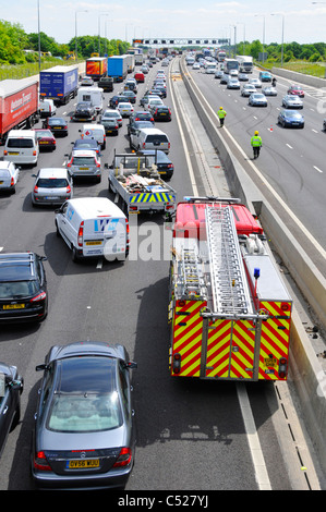 Blick von oben nach unten auf der belebten Autobahn M25 Stau Notdienste teilnehmen zu zwei Unfällen auf beide Richtungen Fire Engine anreisen, Großbritannien Stockfoto