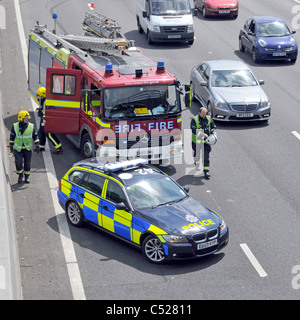 Auf der Suche nach unten von oben Notdienste Londoner Feuerwehr Fire Engine & Essex Police Car crash Unfall unter Brücke Verkehr Autobahn M25 England Stockfoto