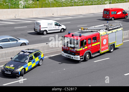 Blick von oben auf die Rettungsdienste Londoner Feuerwehr Fire Engine & Essex Police Car crash Unfall unter Brücke Autobahn M25 England Großbritannien Stockfoto