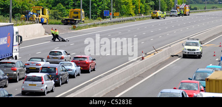 M25 Autobahn-Notdienste kommen Unfall auf gegenüberliegenden Fahrbahnen Autobahnen Agentur Verkehrsbeamte löschen Schutt frei Zusammenbruch layby England Großbritannien Stockfoto