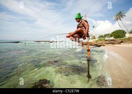 traditionelle Stelzenfischer bei Arbeiten am Strand in der Nähe von Koggala, LKA, Sri Lanka Stockfoto