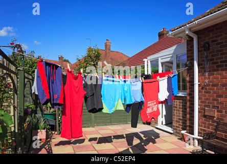 Wäsche hängt an einer Linie außerhalb eines Bungalows in einem städtischen Garten hinter dem Haus. Stockfoto