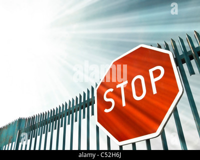Stop-Schild auf dem Tor in Sonnenstrahlen Stockfoto