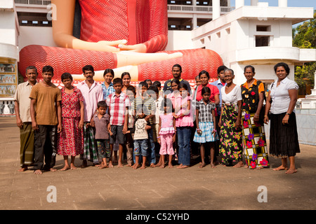 Singhalesischen Großfamilie vor dem Riesen sitzen Buddha-Statue in der Weherahena Tempel von Matara, Sri Lanka, Asien Stockfoto