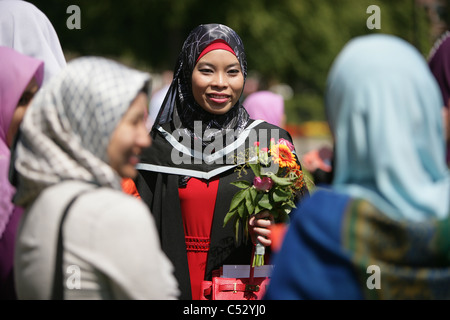 Einer Königin University Graduate lächelt mit Freunden der Familie an der Queens University Belfast, Nordirland. Stockfoto