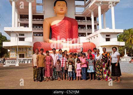 Singhalesischen Großfamilie vor dem Riesen sitzen Buddha-Statue in der Weherahena Tempel von Matara, Sri Lanka, Asien Stockfoto