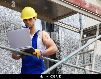 Arbeiter auf der Baustelle mit Laptop. Stockfoto