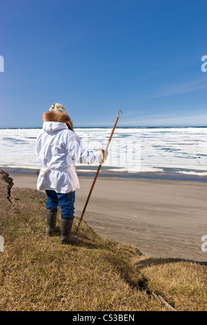 Inupiaq Eskimo hält einen Spazierstock auf alte Utkeagvik Stadt mit Blick auf die Tschuktschensee, Barrow, Alaska Stockfoto
