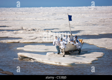 Walfang-Crew schiebt ihre Umiaq neben dem Chuchki Meer Eis am Ende des Walfangs Frühjahrssaison in Barrow, Alaska Arktis, Sommer Stockfoto