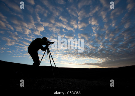 Fotograf, Silhouette, wie er auf Blueberry Hill in der Nähe von Wonder Lake, Denali Nationalpark und Reservat, Alaska Fotos Stockfoto