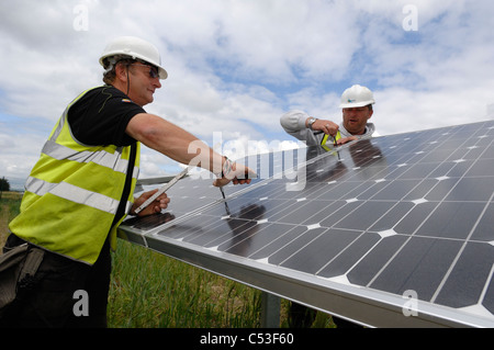 UKs erste solar Kraftwerk im Bau Fen in der Nähe von Louth Lincolnshire und Ecotricity Wind Farm hinter Stockfoto