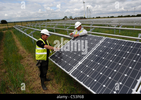 UKs erste solar Kraftwerk im Bau Fen in der Nähe von Louth Lincolnshire und Ecotricity Wind Farm hinter Stockfoto