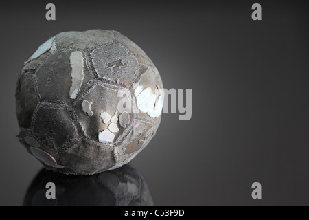 Fußball auf dunklen reflektierenden Oberfläche abgenutzt schlägt alt, Arm oder historische. Kopie-Raum, low-Key. Stockfoto