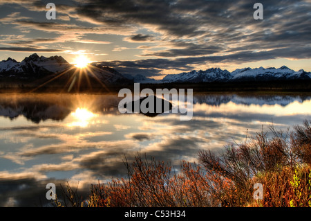 Sonnenaufgang über den Chugach Mountains mit einem Teich und Beaver Lodge im Vordergrund, Chugach National Forest, Alaska Stockfoto