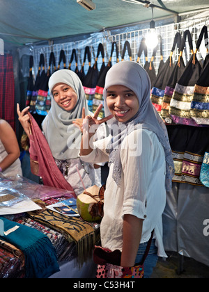 Muslimische Mädchen, die beim Einkaufen traditionelle Hijab-Pose für die Kamera tragen Stockfoto