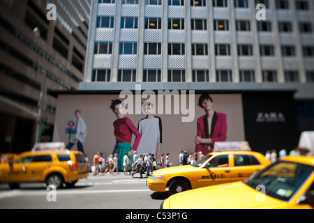 Ein Plakat auf einer Konstruktion, die Schuppen auf der Fifth Avenue in New York kündigt die eminente Ankunft eines Zara-Bekleidungsgeschäft Stockfoto