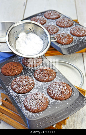 frisch gebackenes Schokoladen-Muffins mit Puderzucker bestreut Stockfoto