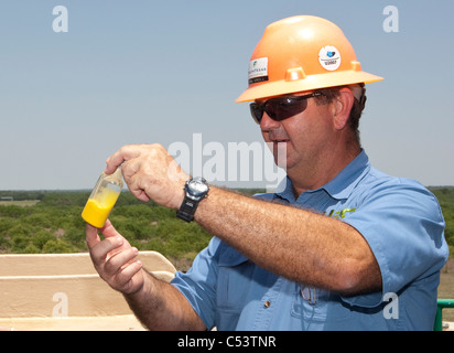 Weißen männlicher Arbeitnehmer hält eine Probe von verarbeiteten Uran in einem Uran-Aufbereitungsanlage in Texas Stockfoto