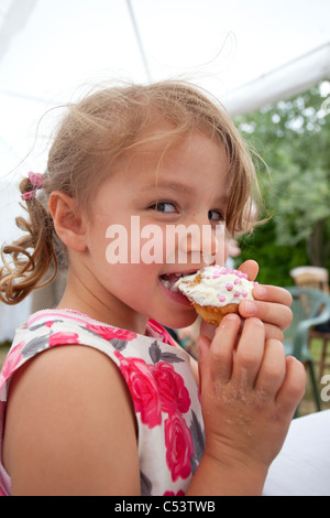 junges Mädchen essen Muffins Stockfoto