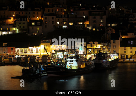 Beleuchteten Fischerboote im Hafen von Brixham bei Nacht. Devon, Großbritannien Stockfoto