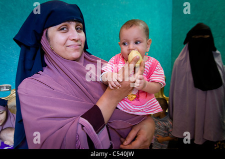 Ägypten, FAYOUM: Frauen mit Kindern in einer Kindklasse Ernährung in Gablaa Dorf. Stockfoto