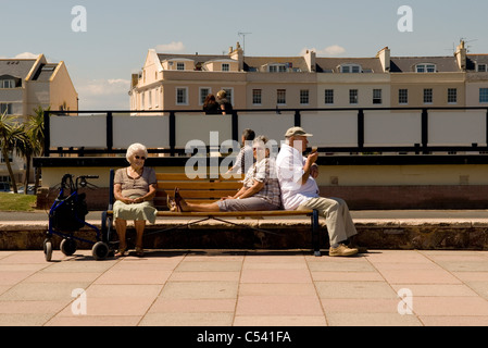 Ältere Menschen sitzen auf einer Bank entspannen und Eis essen. Stockfoto