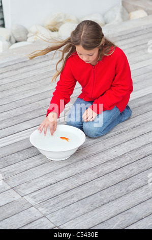Mädchen, die einen Fisch in eine Schüssel zu berühren Stockfoto