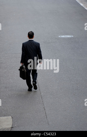 Rückansicht eines Geschäftsmannes zu Fuß eine Straße, Tokyo, Japan Stockfoto