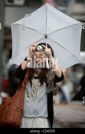 Frau, die eine Aufnahme mit einer Kamera, Tokyo, Japan Stockfoto