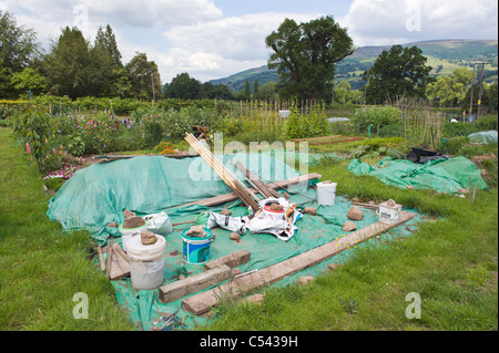 Grundstück bedeckt mit grünem Plastik unterdrückt Unkrautwachstum auf Gemeinschaft Kleingärten im Dorf von Llangattock Powys South Wales UK Stockfoto