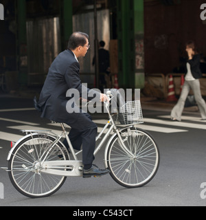Geschäftsmann, mit dem Fahrrad auf einer Straße, Ginza, Chuo Ward, Tokio, Japan Stockfoto