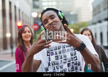 Porträt der Afro-Amerikaner Musikhören mit Freunden im Hintergrund Stockfoto