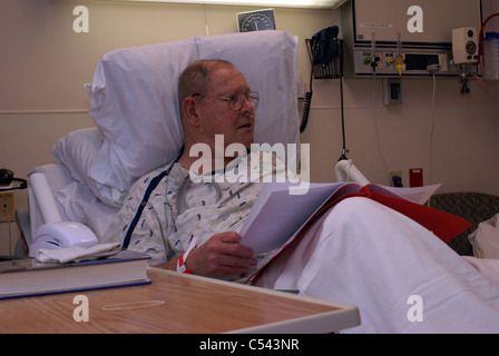 Krankenhaus-Patienten lesen von Informationen im Krankenhausbett Stockfoto