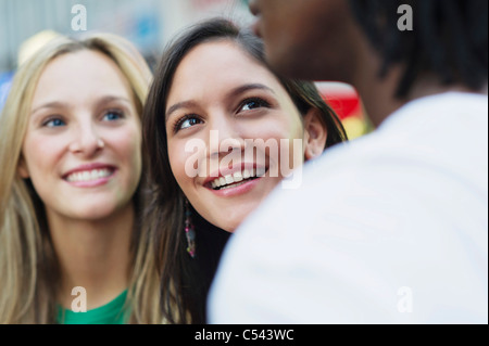 Zwei Frauen ein Mann schauen und Lächeln Stockfoto