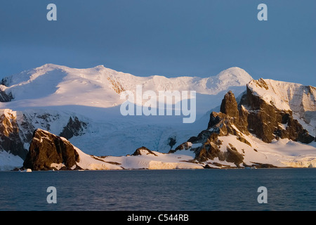 Wunderschöne schneebedeckte Berge bei Sonnenuntergang. Bild in der Antarktis. Stockfoto