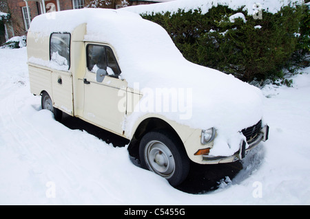 Ein alter klassischer französischer Citroën 2CV (deux chevaux) Van, der im Winterschnee liegt und in Dorchester, Dorset, England, Vereinigtes Königreich geparkt ist. Stockfoto