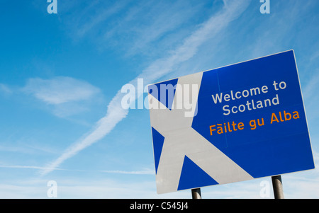 Schottland-Grenze-Zeichen an der Northumberland-Grenze vor einem weißen Kreuz Flugzeug Trail in den blauen Himmel Stockfoto