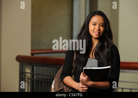 Porträt von asiatische Studentin mit Büchern im Innenbereich Stockfoto