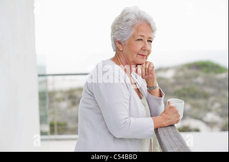 Ältere Frau hält eine Kaffeetasse Stockfoto