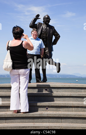 Morecambe, Lancashire, England, UK. Touristen, die ein Foto mit Eric Morecambe Statue am Meer in seiner Heimatstadt Stockfoto
