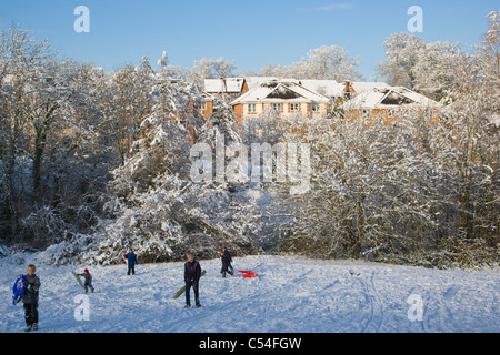 Verschneite Landschaft mit Kinder mit Schlitten, Burghfield Common, Reading, Berkshire, England, UK Stockfoto