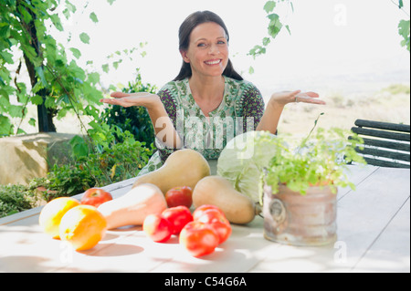 Porträt einer reifen Frau mit Gemüse am Tisch sitzen Stockfoto